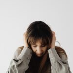 頭を抱えて悩む女性