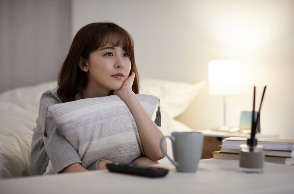 間接照明をつけて、クションを抱えてゆっくりする女性