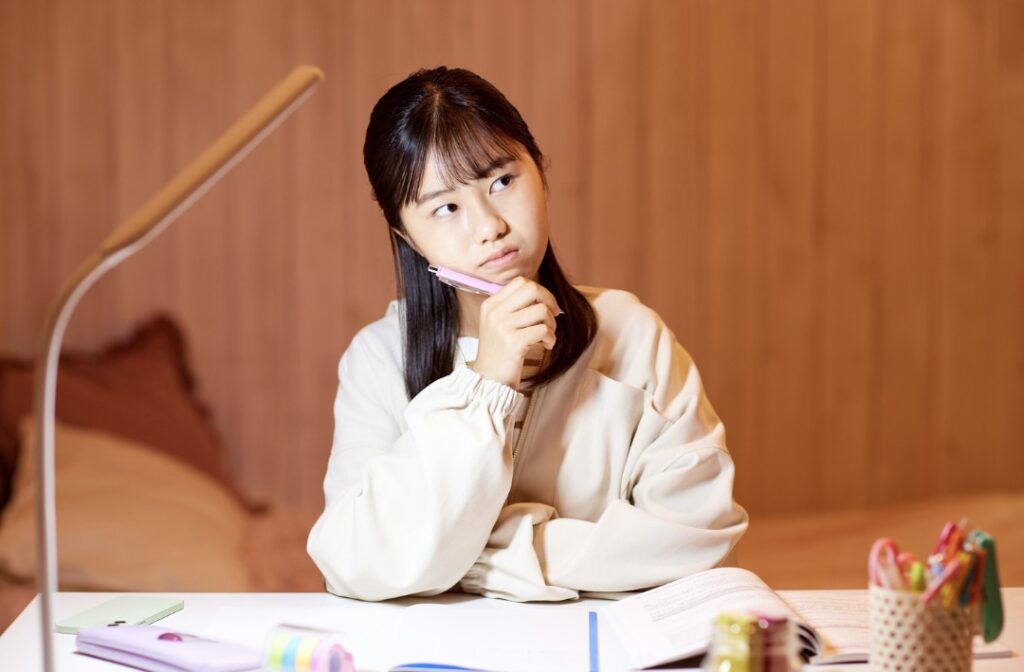 ノートを開きながら考えている様子の女性