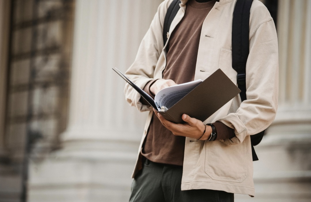 学生がファイルを読みながら歩いている様子