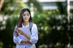 緊張した面持ちでノートを抱えて歩く女性