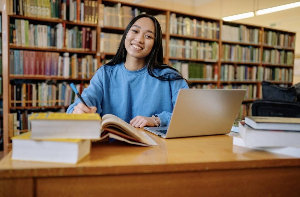 図書館で、笑顔で勉強をしている女性