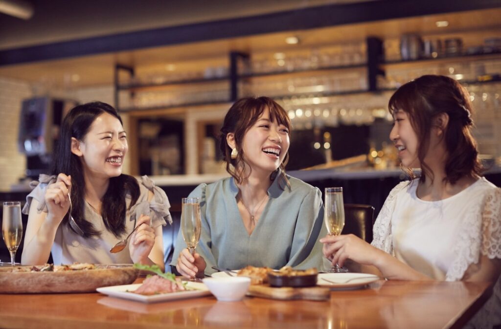 3人の女性が笑顔でご飯を食べている様子