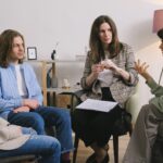 4人の男女が真剣な顔で会話をしている様子