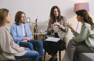4人の男女が真剣な顔で会話をしている様子